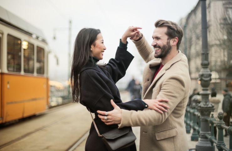 Due ragazzi ballano sorridenti in centro città